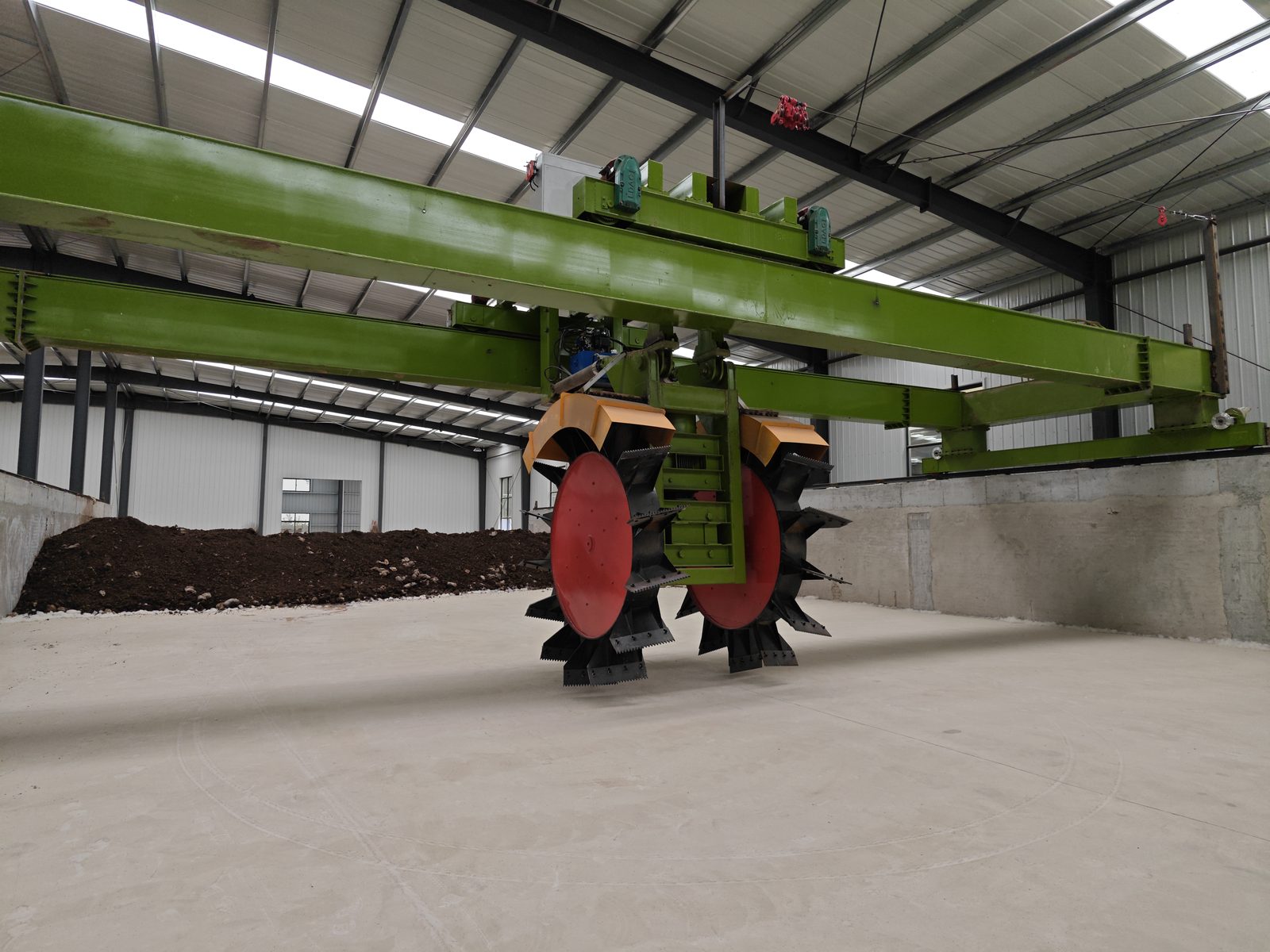 Small scale compost turner working a windrow on a farm